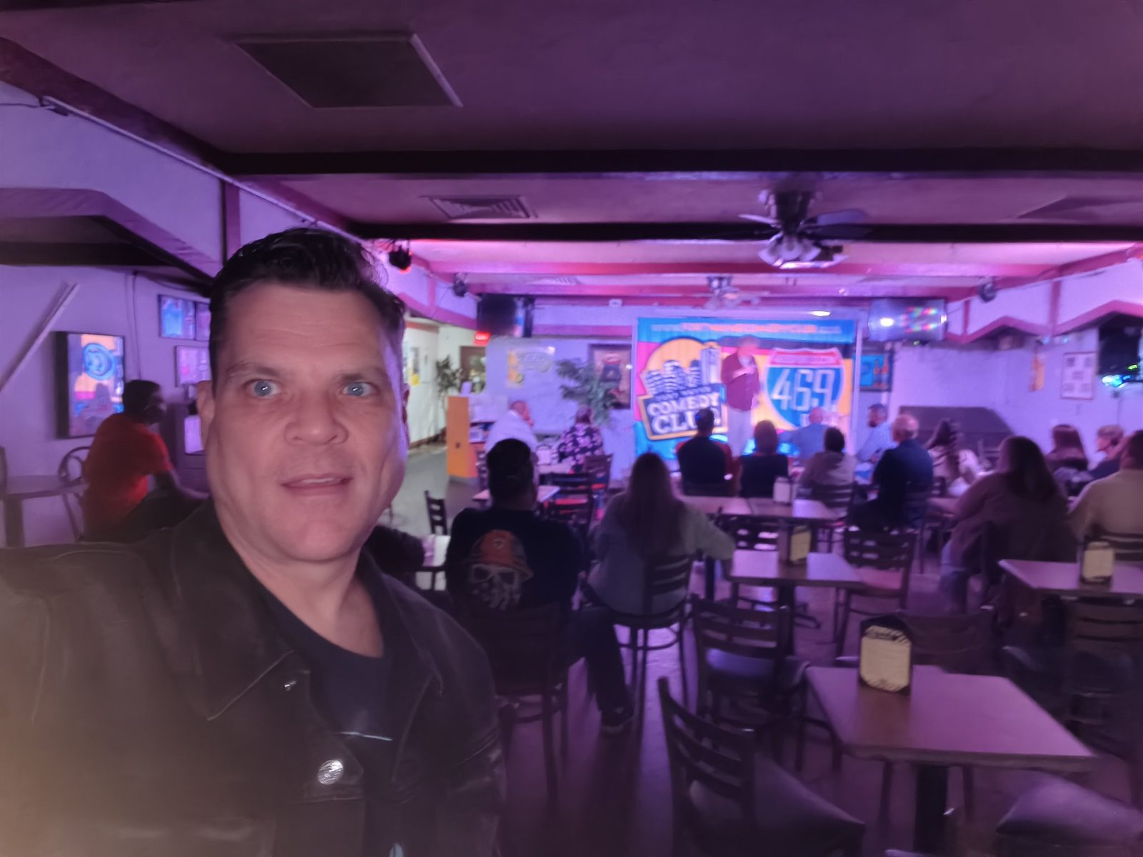 Bam at the comedy club with the audience behind him