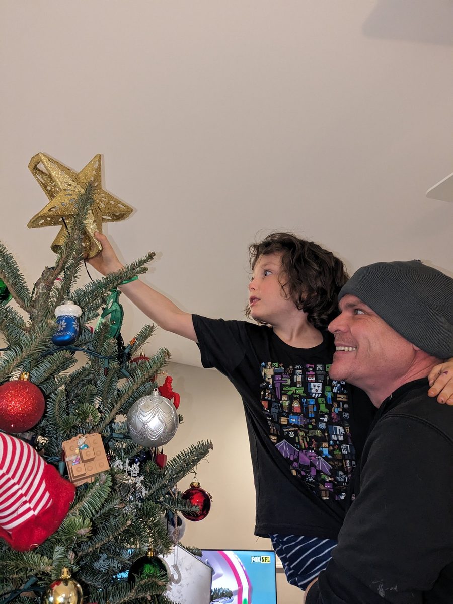 Bam lifting his kid to top the Christmas tree